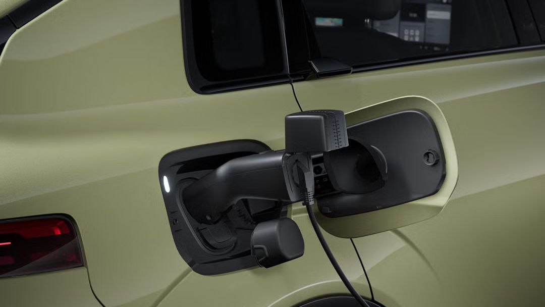 Nahaufnahme des Audi A2 e-tron von rechts hinten. Am geöffneten Ladeanschluss ist ein Stromkabel angeschlossen.